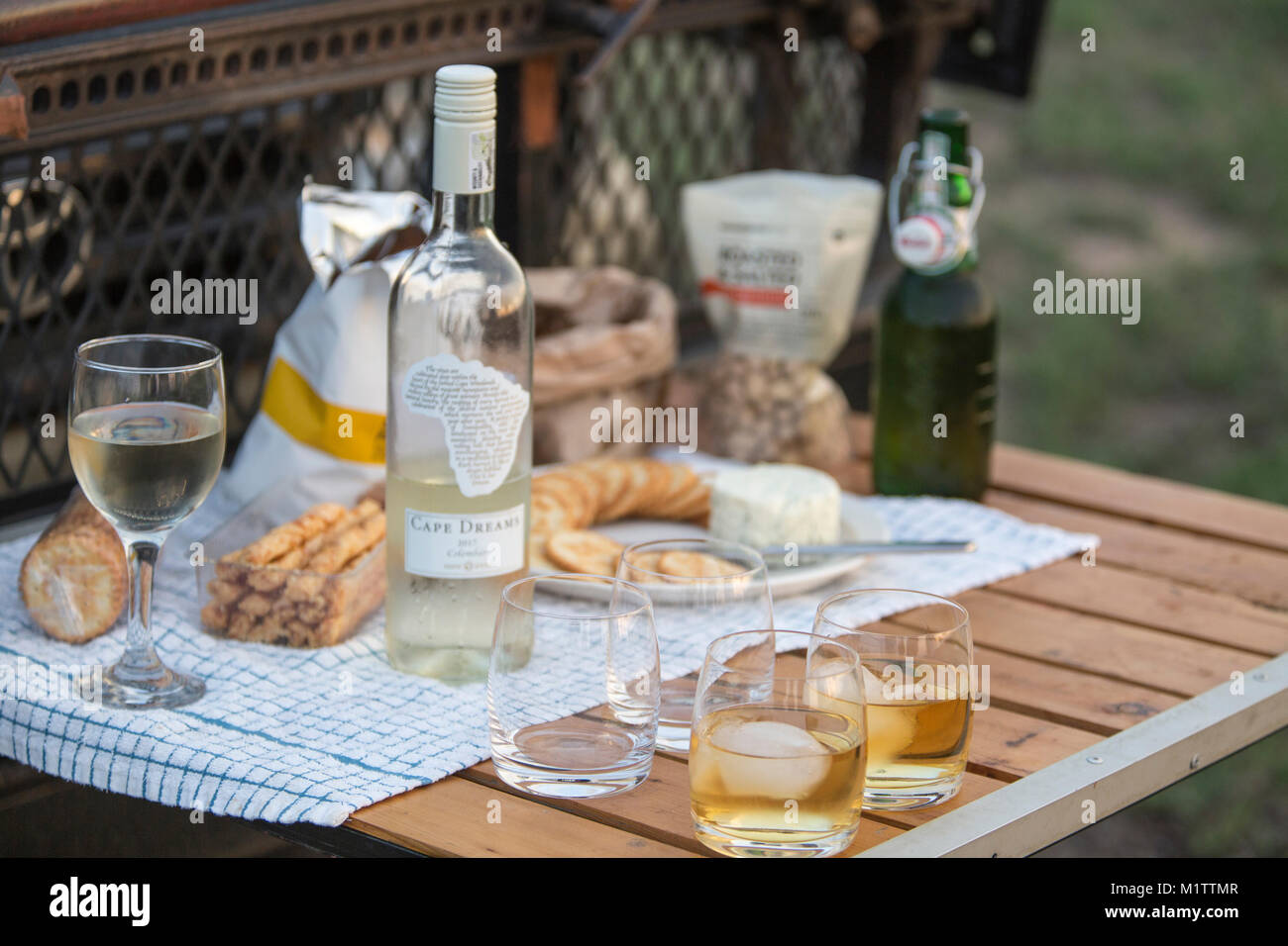 Beverages and snacks on a wooden table mounted on the front of a game drive vehicle for guests on safari Stock Photo