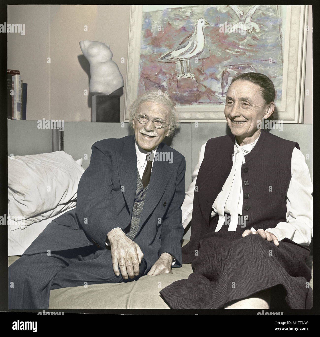 Photographer Alfred Stieglitz and artist Georgia O’Keeffe in New York City. The married couple are at "An American Place" for an exhibition of John Marin in 1942. Artwork on wall is “Sea and Gulls” by Marin. Stock Photo