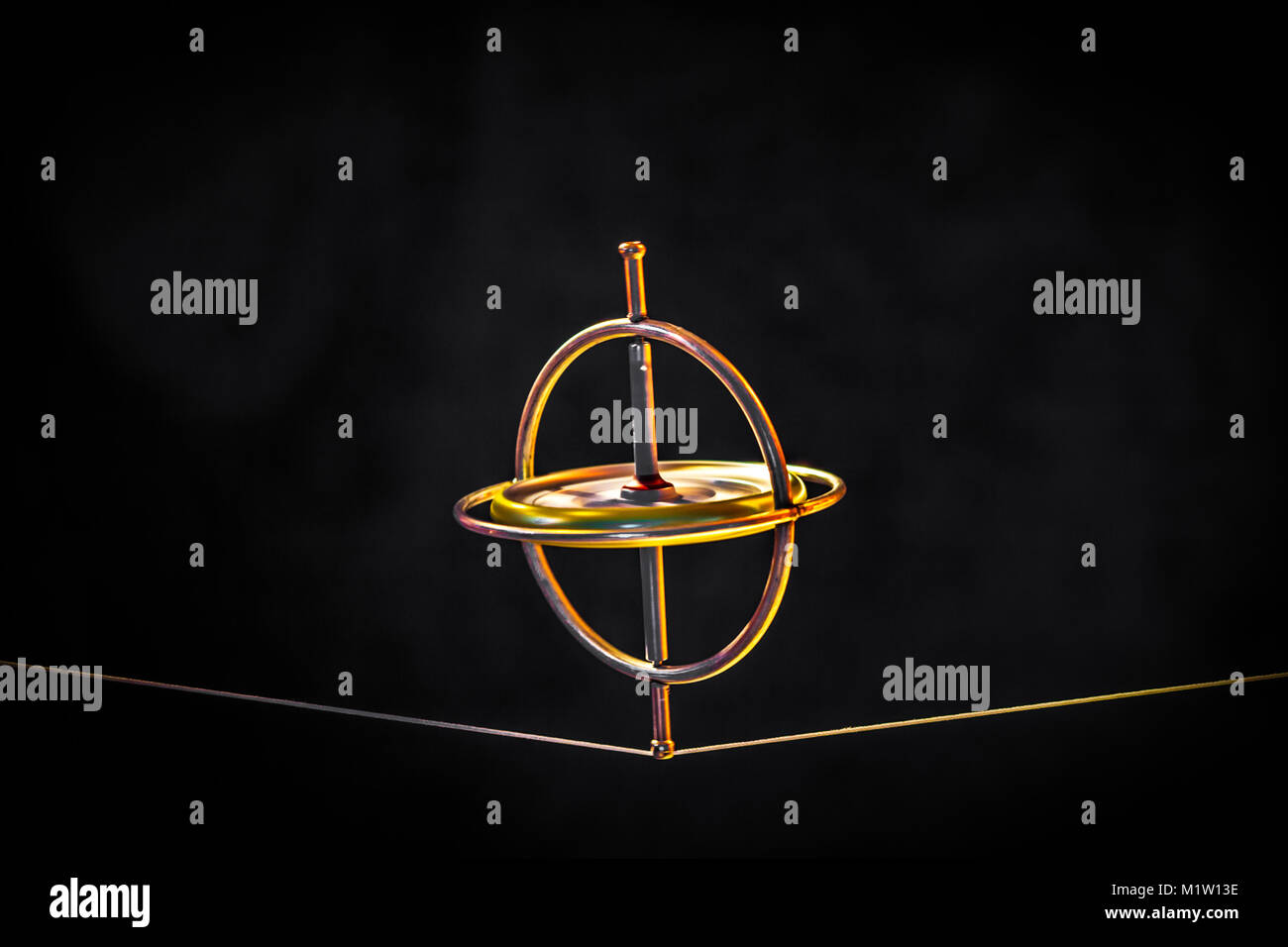 Toy gyroscope balancing on a line against a dark background Stock Photo ...
