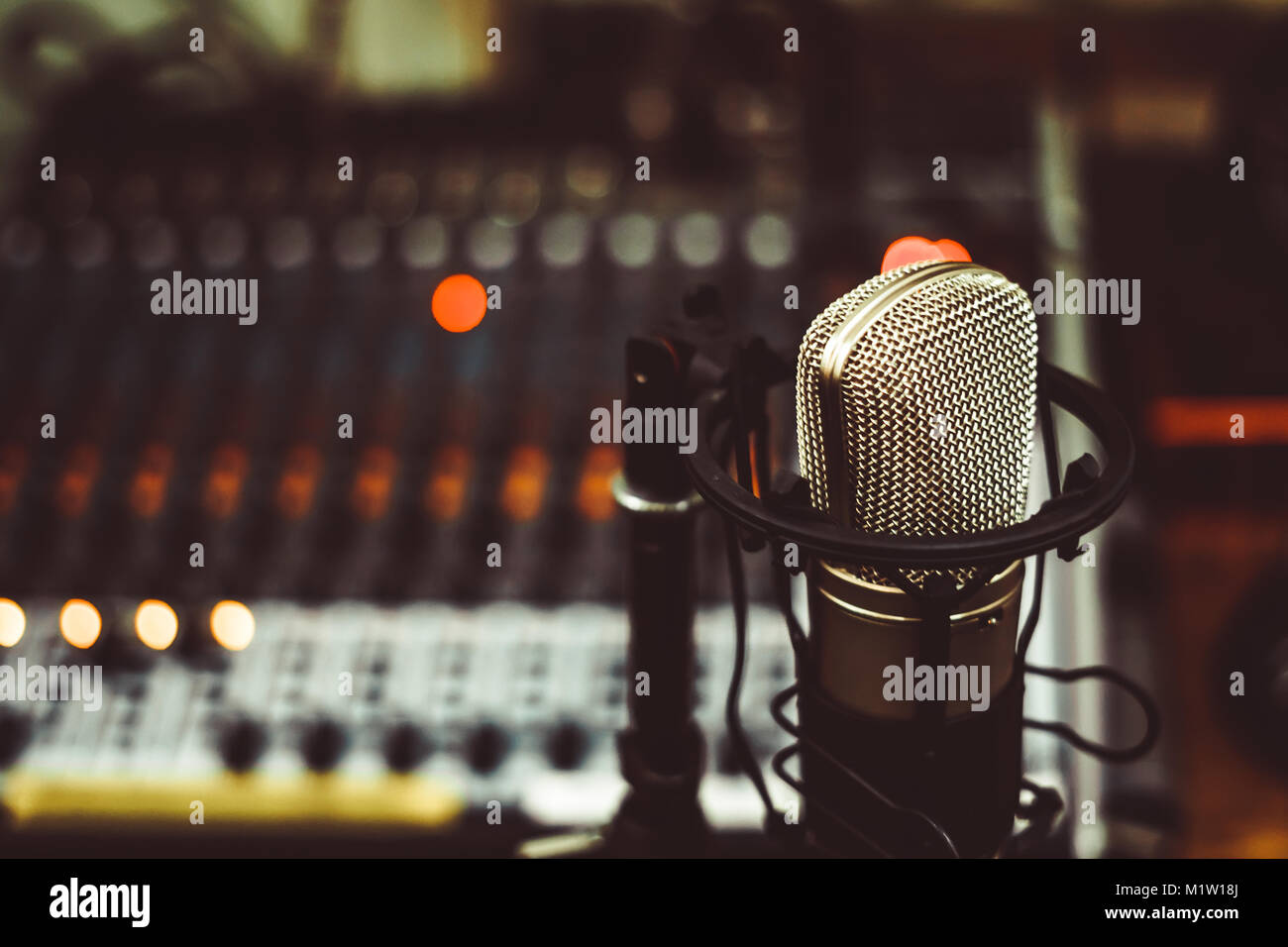 Professional condenser studio microphone over the musician blurred  background and audio mixer, Musical instrument Concept Stock Photo - Alamy