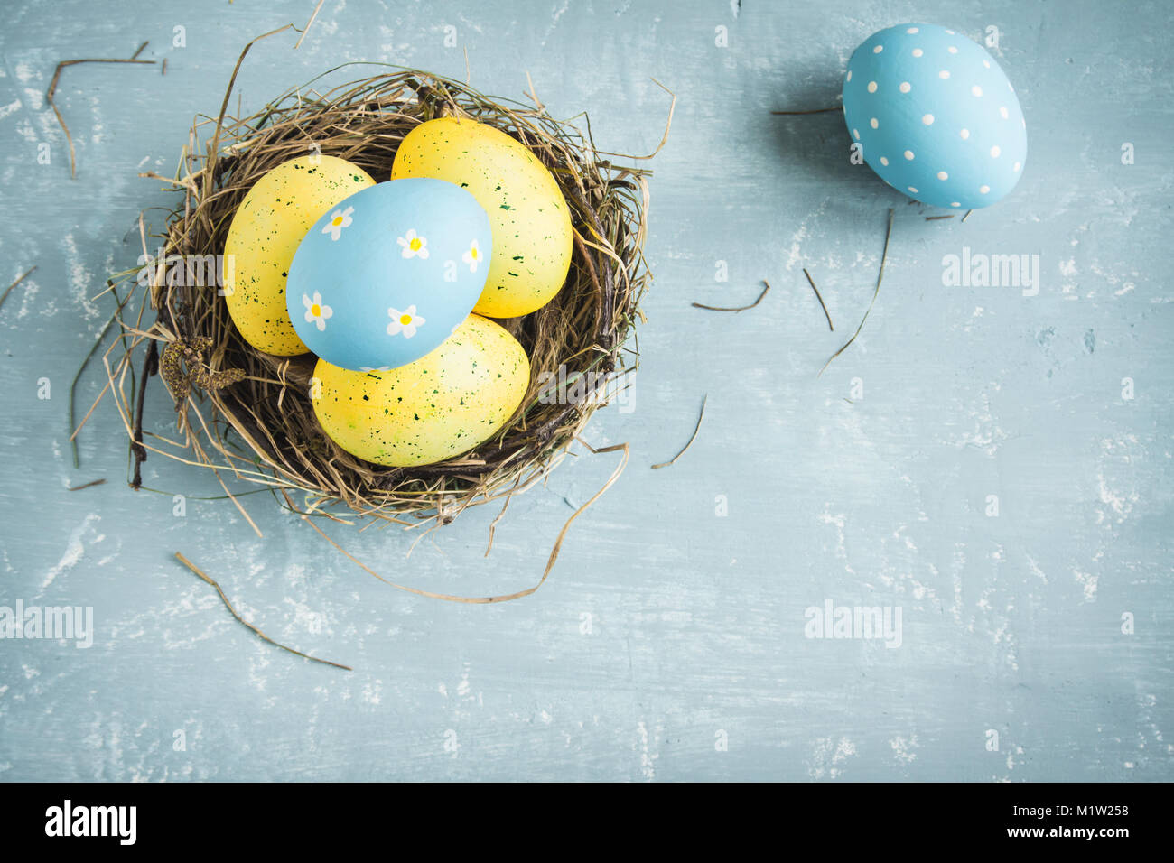 Easter Eggs in bird Nest on blue wooden background. Decorated easter ...