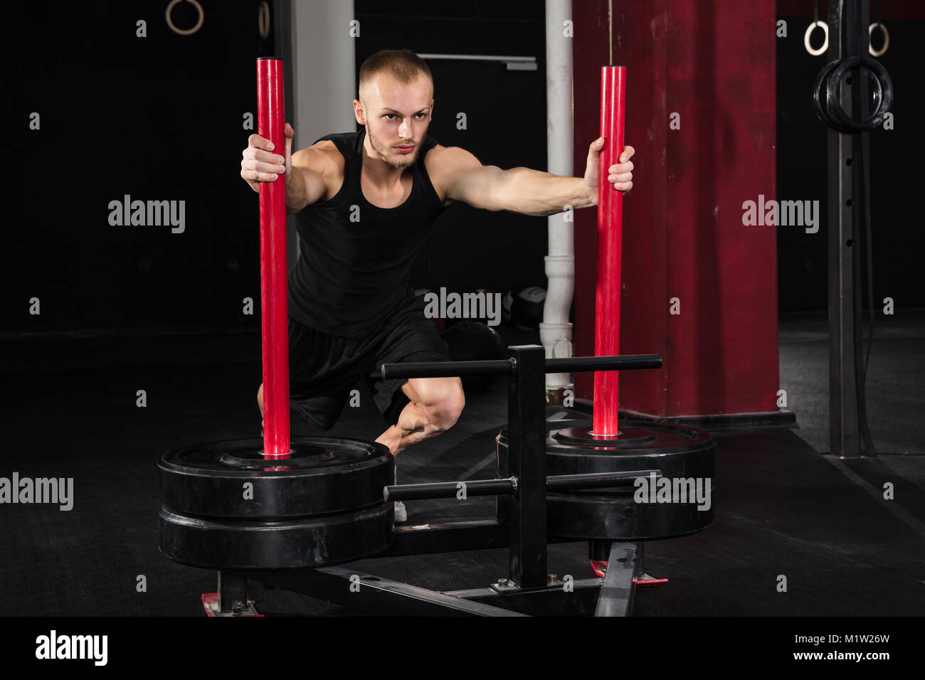 Young Athlete Man Getting Trained On Gym Equipment In Gym Stock Photo