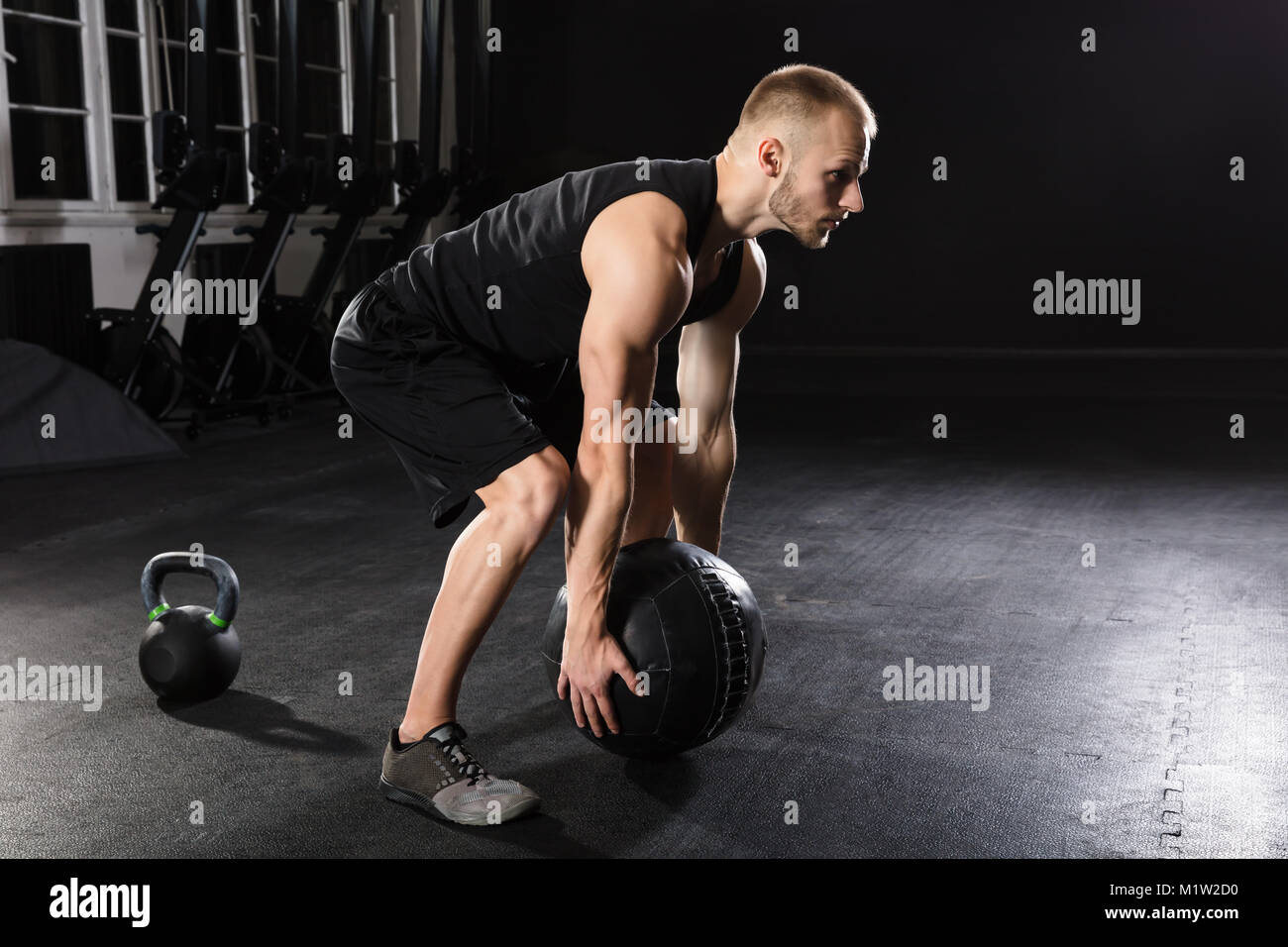 Young Athlete Man Doing Exercise With Medicine Ball In The Gym Stock Photo
