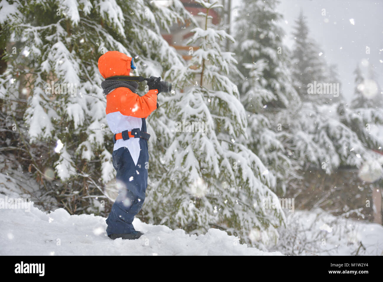 Happy kid with photo camera taking pictures in winter snowy day Stock Photo