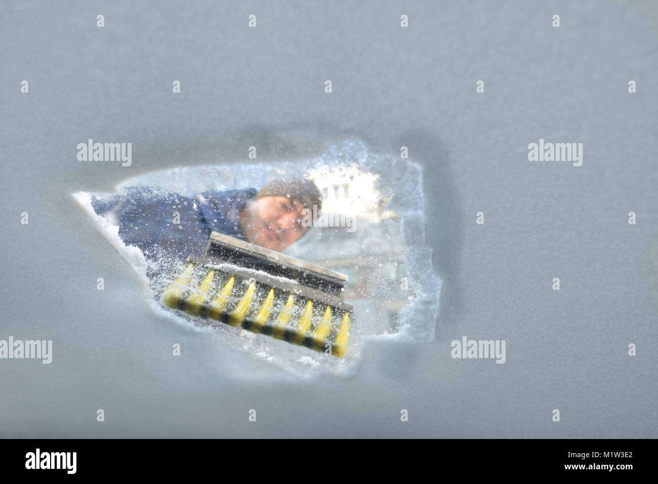 Winter season driving - scraping ice from a windshield. Photo has been taken from the inside of the car Stock Photo