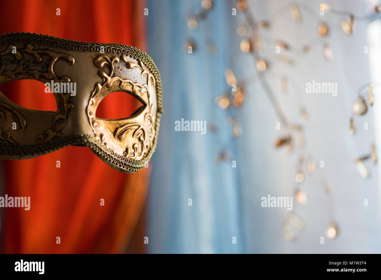 Golden Venetian mask for eyes decorated with music notes written on it Stock Photo