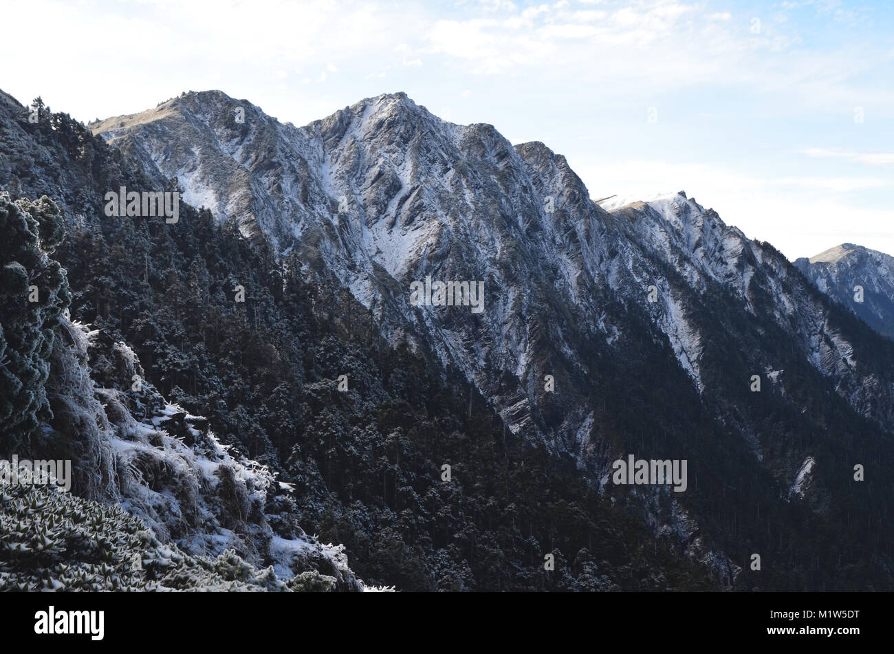 Snow and ice cover the highest peaks of Qilai mountains - Chilai Shan range, Taroko National park, northeastern Taiwan, in an early winter dawn Stock Photo