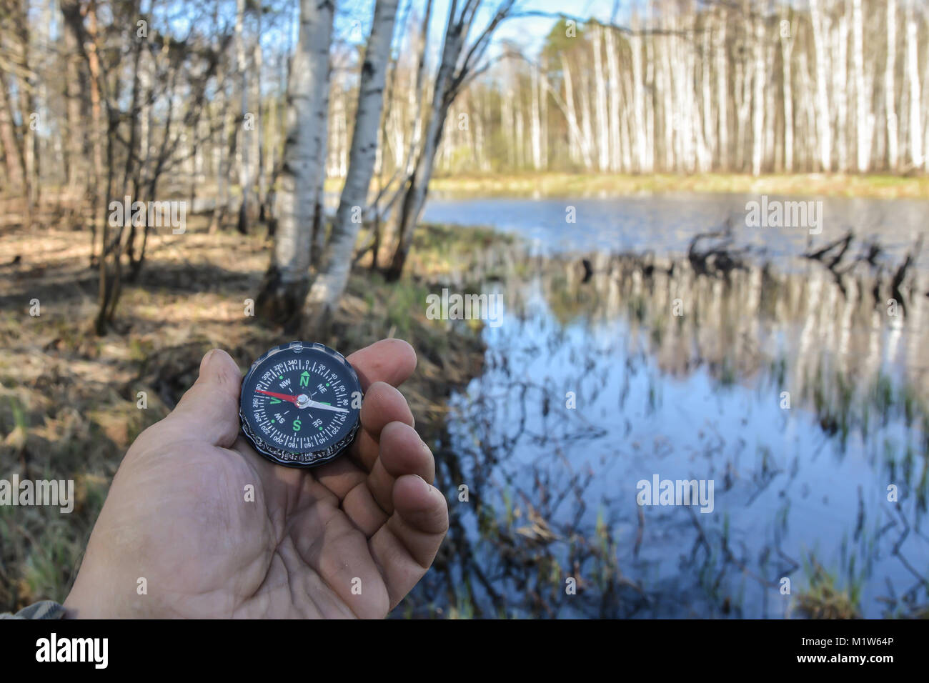 Compass in hand. Orientation on a walk with a navigation device. Stock Photo