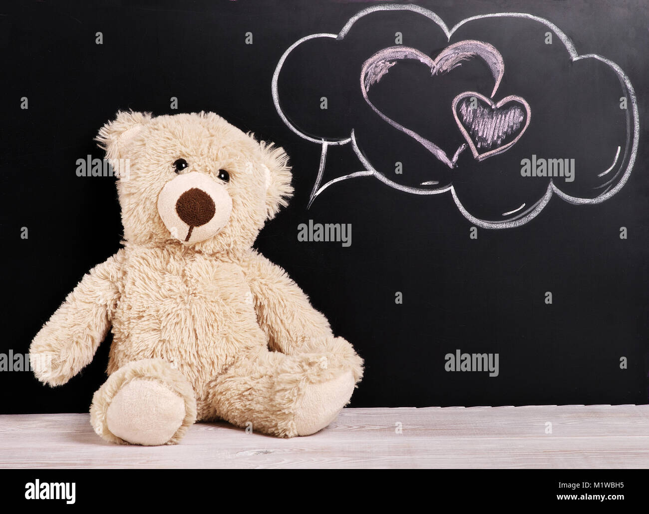 Teddy bear with thoughts of love near the chalk Board, Valentines day background Stock Photo