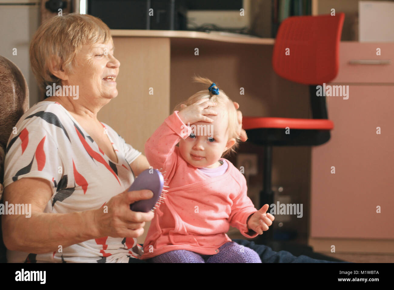 Little girl child playing with grandmother at home Stock Photo - Alamy