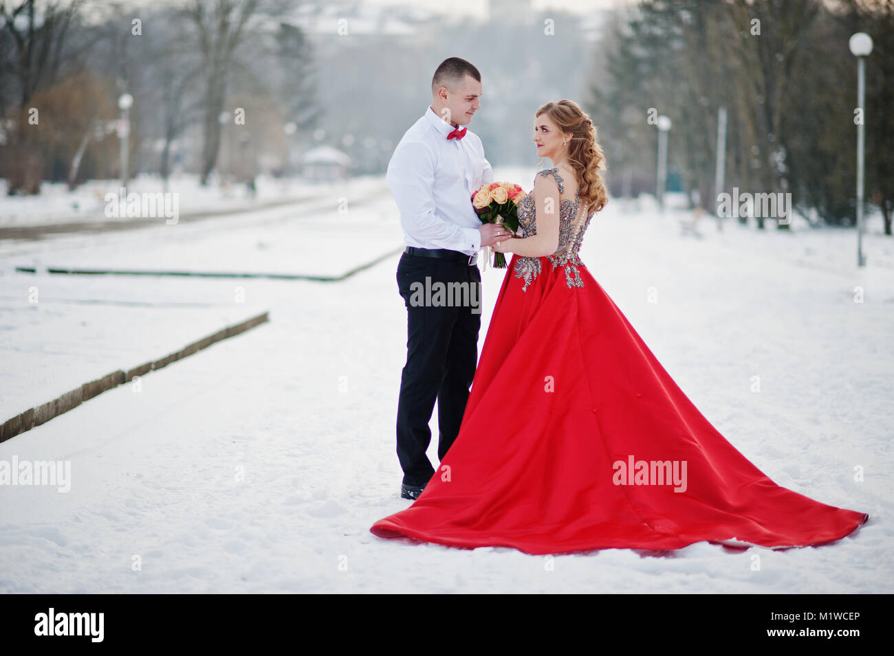 Amazing couple in winter fairytale forest in love. Girl in red beautiful  dress. Valentine's Day theme Stock Photo - Alamy