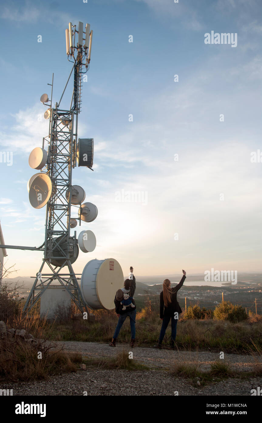 Two girls searching for signal on the hill Stock Photo Alamy