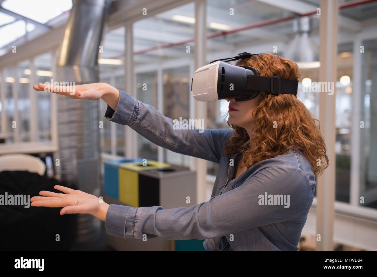 Female executive using virtual reality headset Stock Photo - Alamy