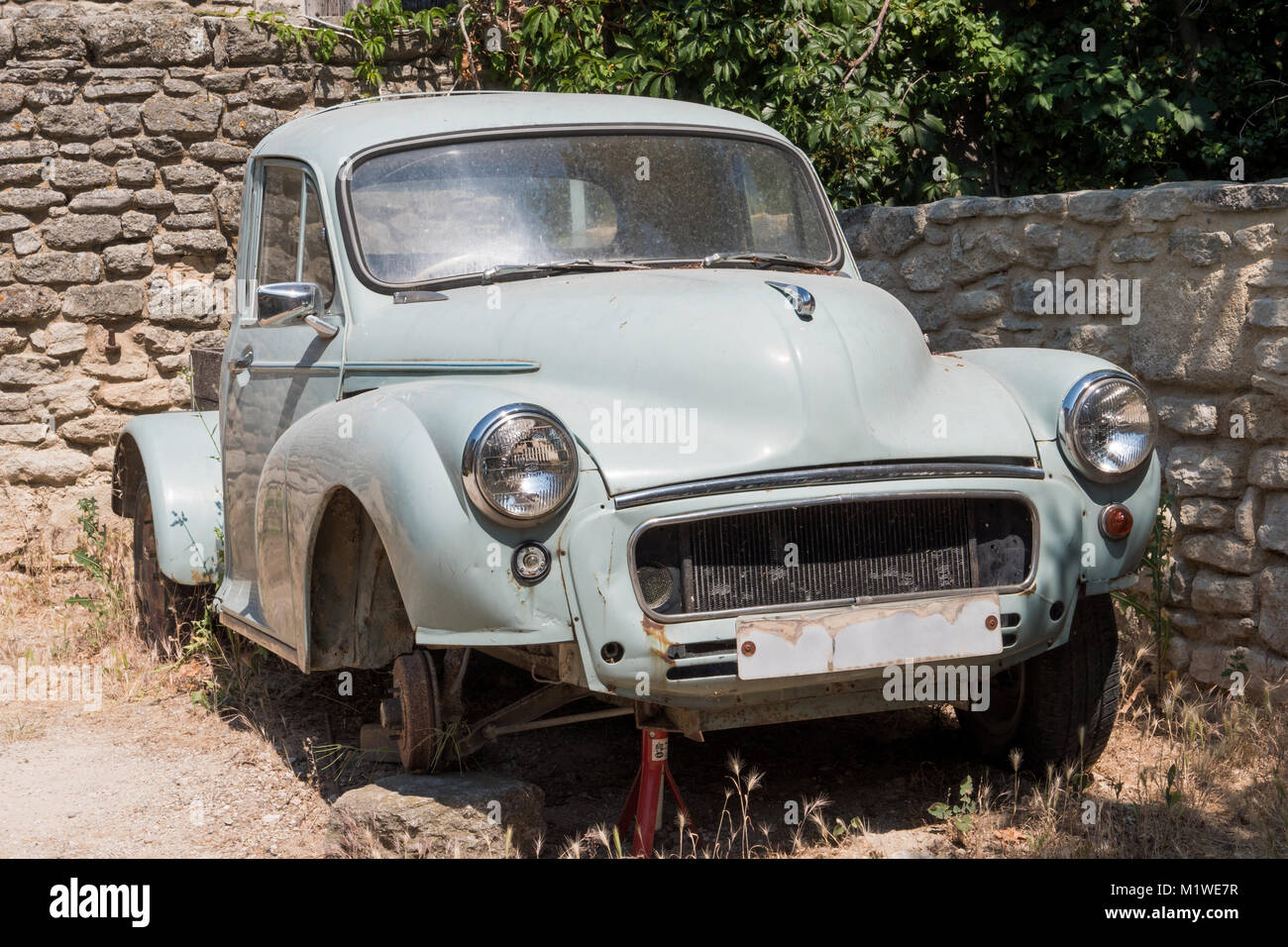 Old abandoned pickup rusting near stone wall Stock Photo Alamy