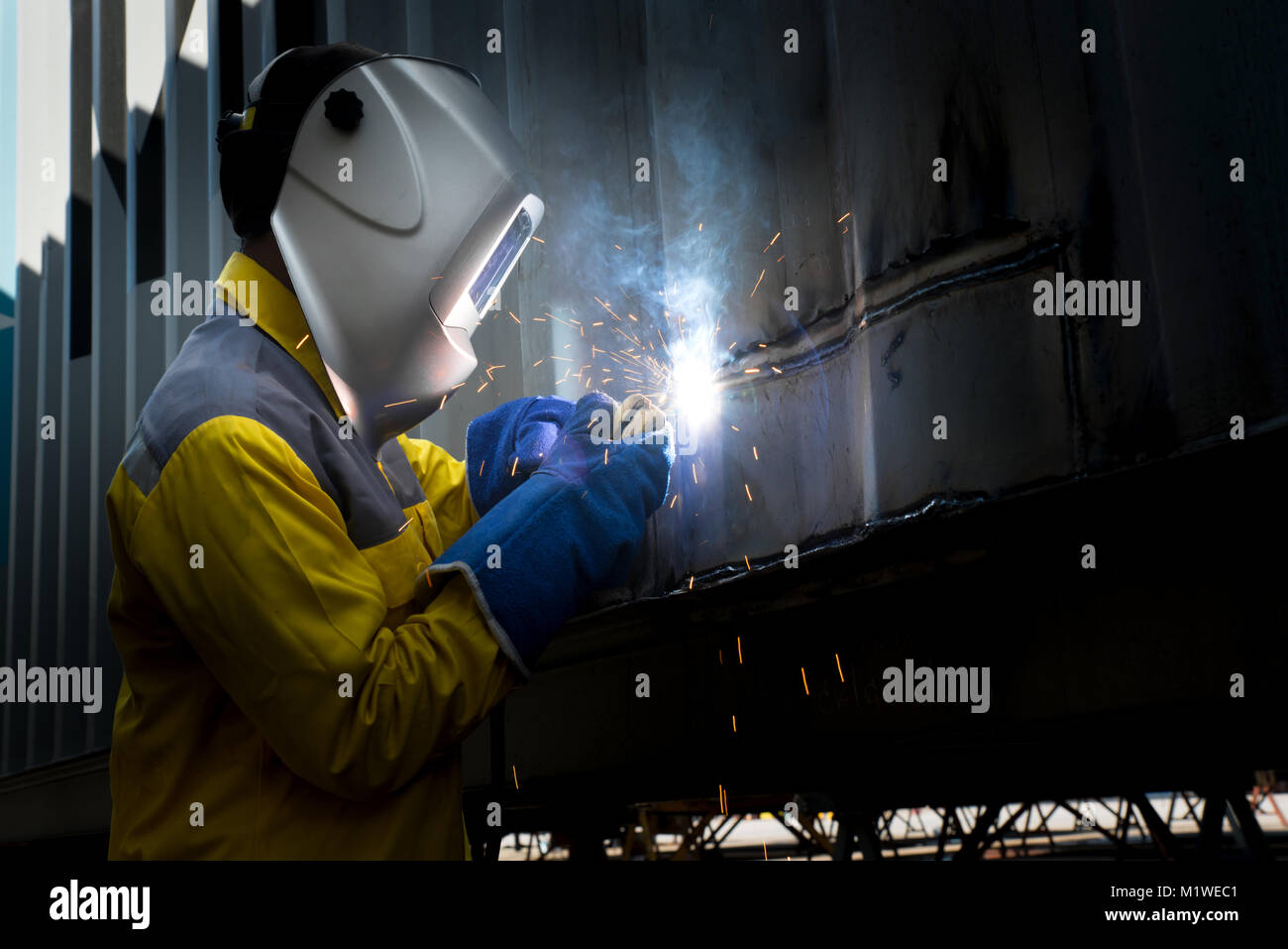 Industry worker with welding steel to repair container structures