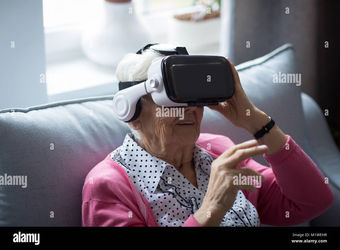 Senior woman using virtual reality headset Stock Photo - Alamy