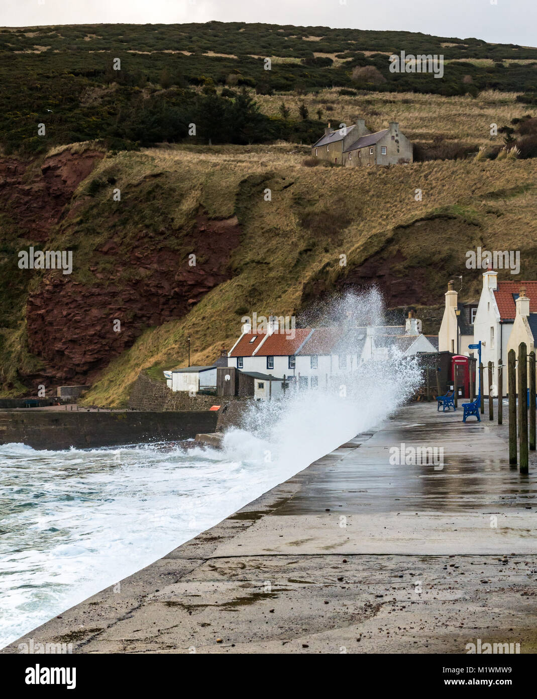 Pennan, Aberdeenshire, Scotland, United Kingdom, 2nd February 2018. The strong winds create a surge in the North Sea along the Northeast coast of Scotland, with large waves splashing against the promenade in the picturesque village, famous for being a film location for the movie 'Local Hero' Stock Photo