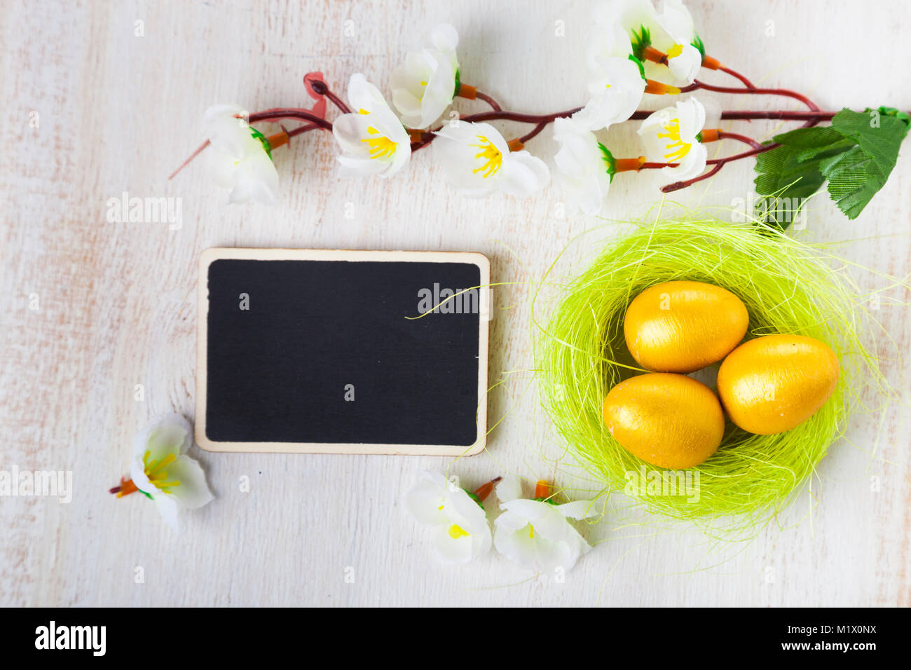 Golden eggs in a nest on a wooden background. Easter still life with ...