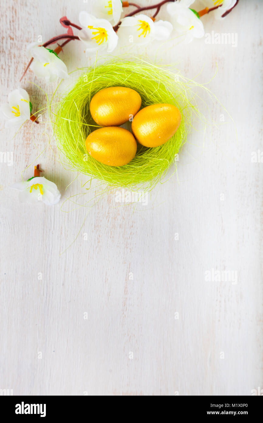 Golden eggs in a nest on a wooden background. Easter still life with ...