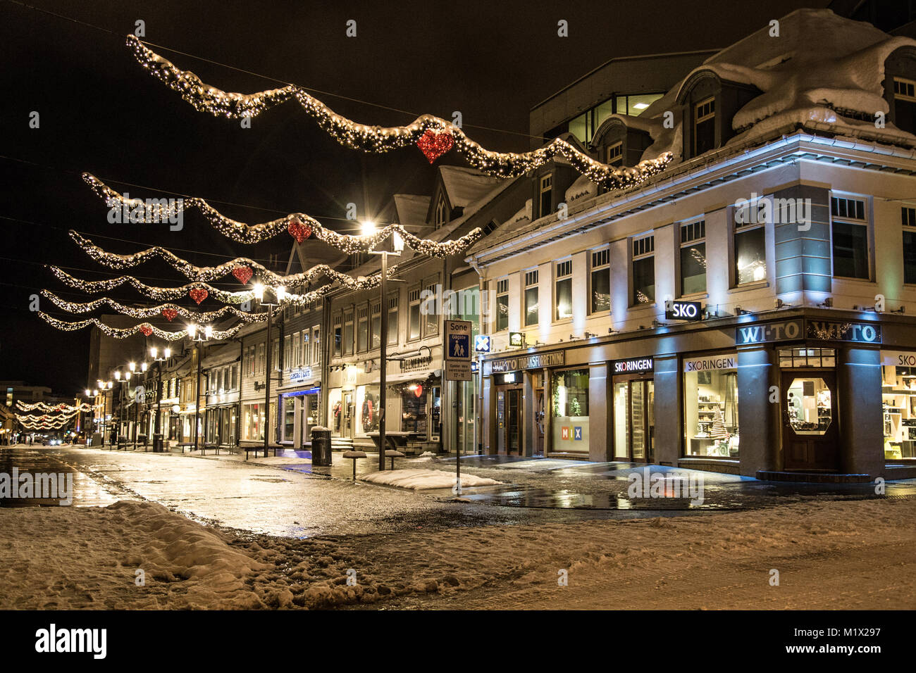 A view of the central street of Tromsø, Storgata, at polar night in winter, all lit up, with decorations for Christmas. Stock Photo