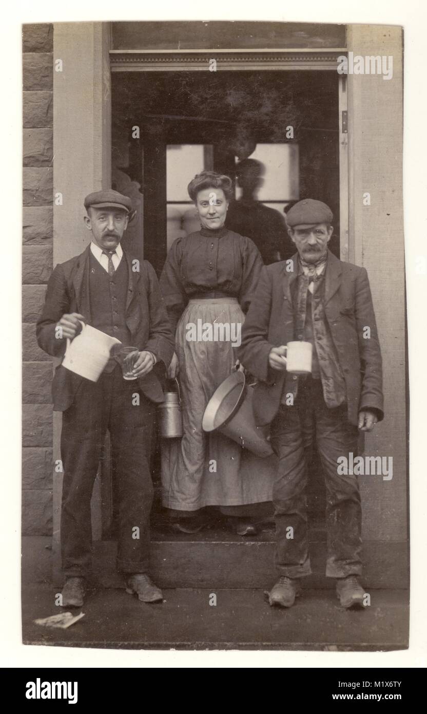 Cut down postcard portrait of milk maid and workers wearing clogs, typical rustic clothing attire, caps, with milk jug, borough of Rosendale, Rawtenstall, Ramsbottom (Lancashire) area, U.K. circa 1906 Stock Photo