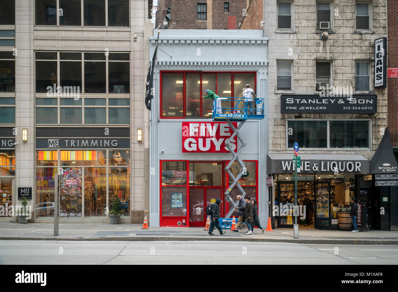 Workers put the finishing touches on the exterior of a new Five Guys Burgers and Fries restaurant in Midtown Manhattan in New York on Saturday, January 27, 2018. (Â© Richard B. Levine) Stock Photo