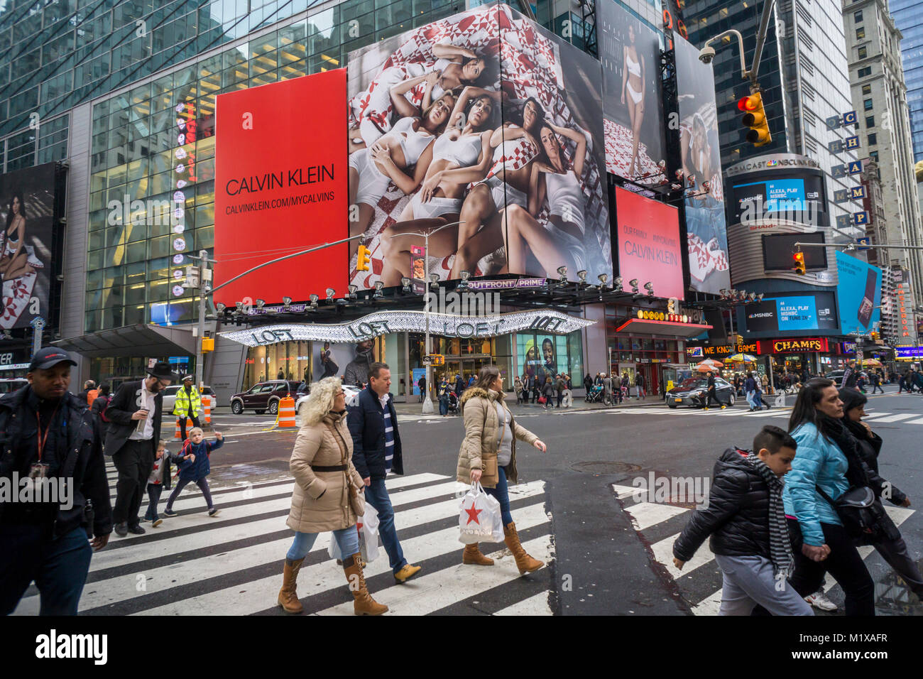 Pedestrians pass all five Kardashian sisters posing on a billboard in
