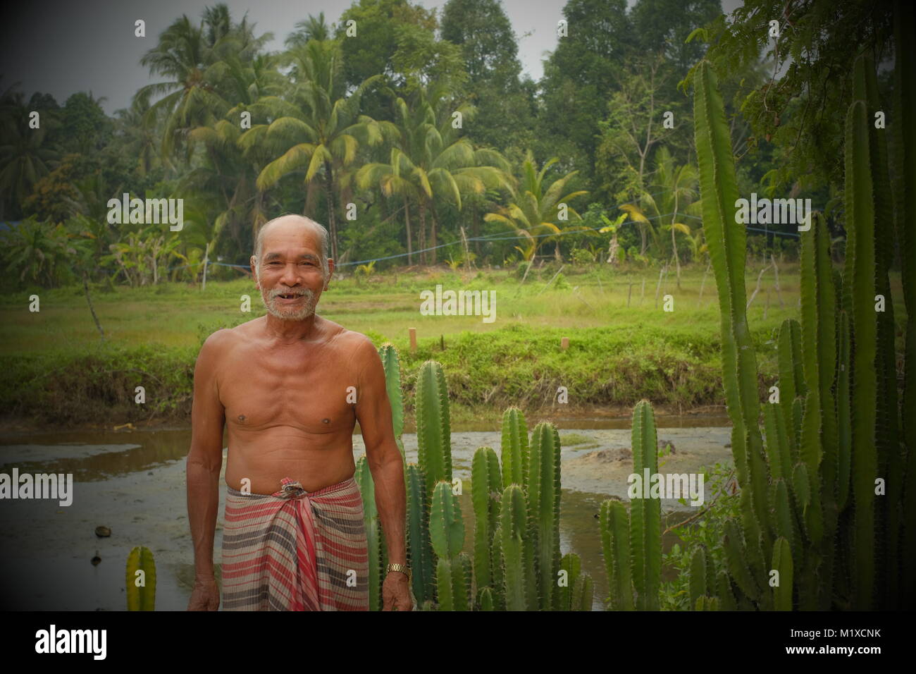 Friendly old man poses for a photo in koh Yao Noi, a Thai island in the Andaman Sea. 20-Jan-2018 Stock Photo