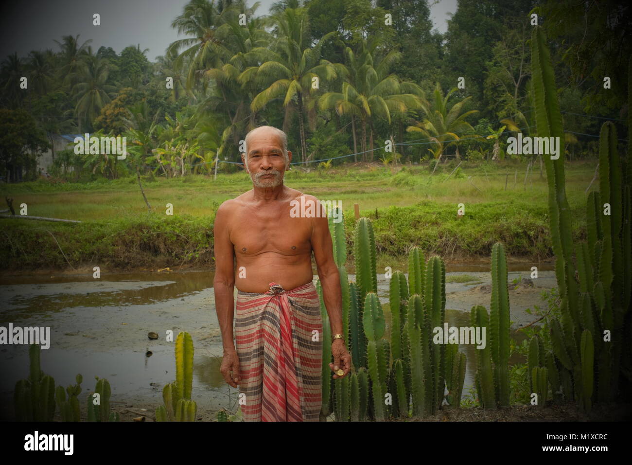 Friendly old man poses for a photo in koh Yao Noi, a Thai island in the Andaman Sea. 20-Jan-2018 Stock Photo