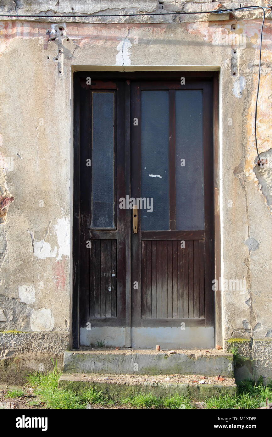 Ruined house wooden doors with glass area and missing door knob
