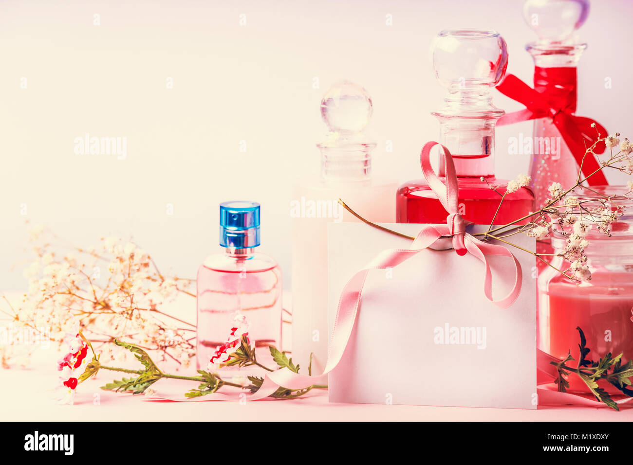Various cosmetic products bottles and jars with flowers and empty paper