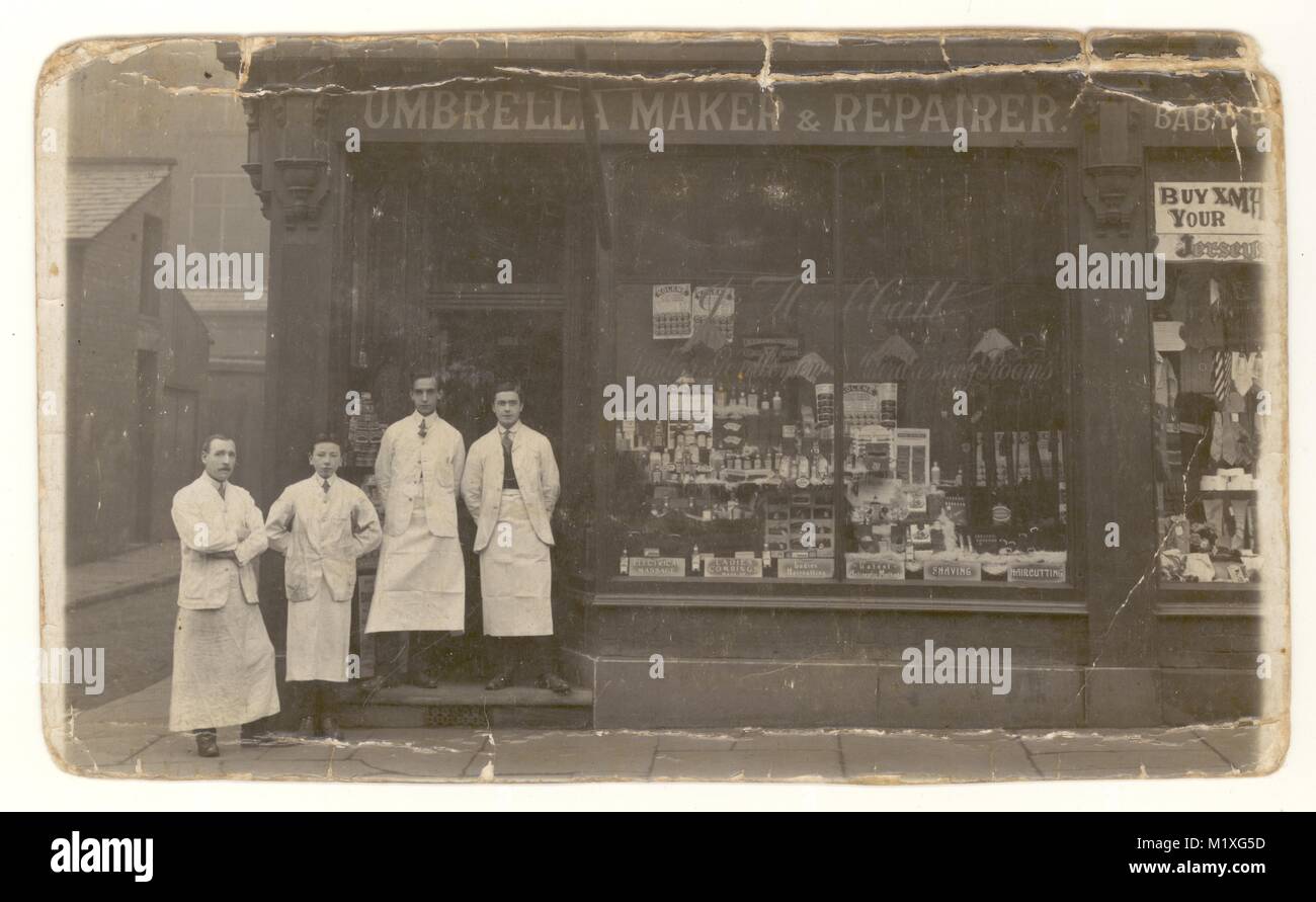 Original early 1900's postcard of former umbrella maker shop, selling hairdressing supplies, staff posing for a photograph outside the shop, Bolton or Heywood, Greater Manchester, England, U.K. circa 1910. Edwardian shop. Victorian shop. Stock Photo