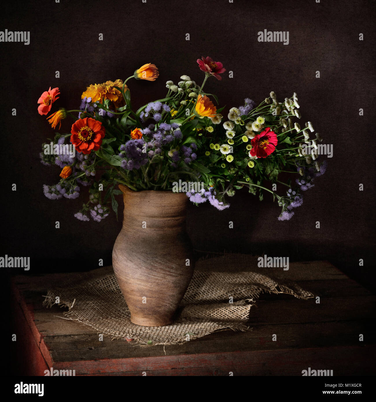 Bouquet from field and garden flowers in a clay vessel in a rural style Stock Photo