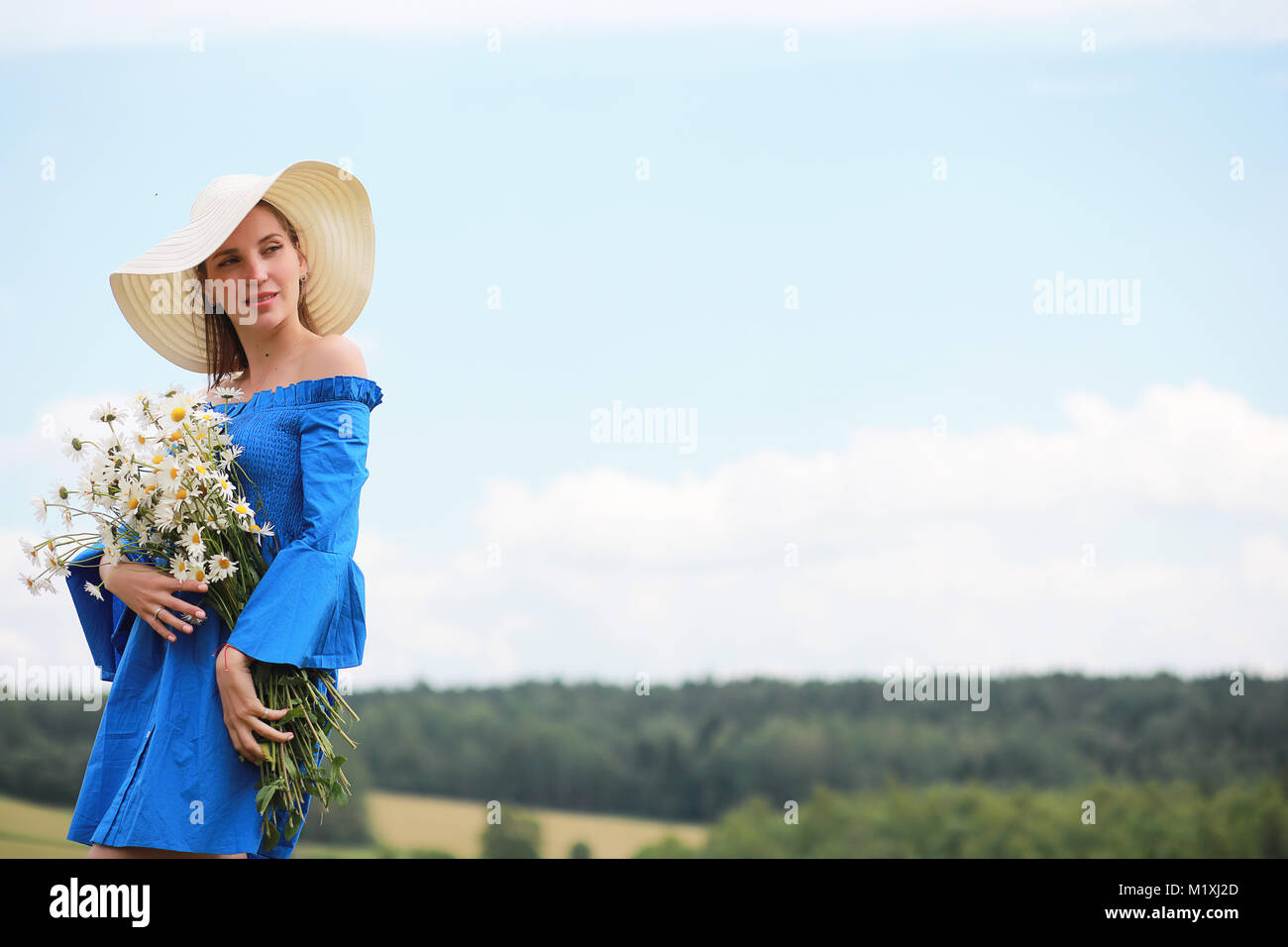 Young cute girl in a hat in a field at sunset Stock Photo - Alamy