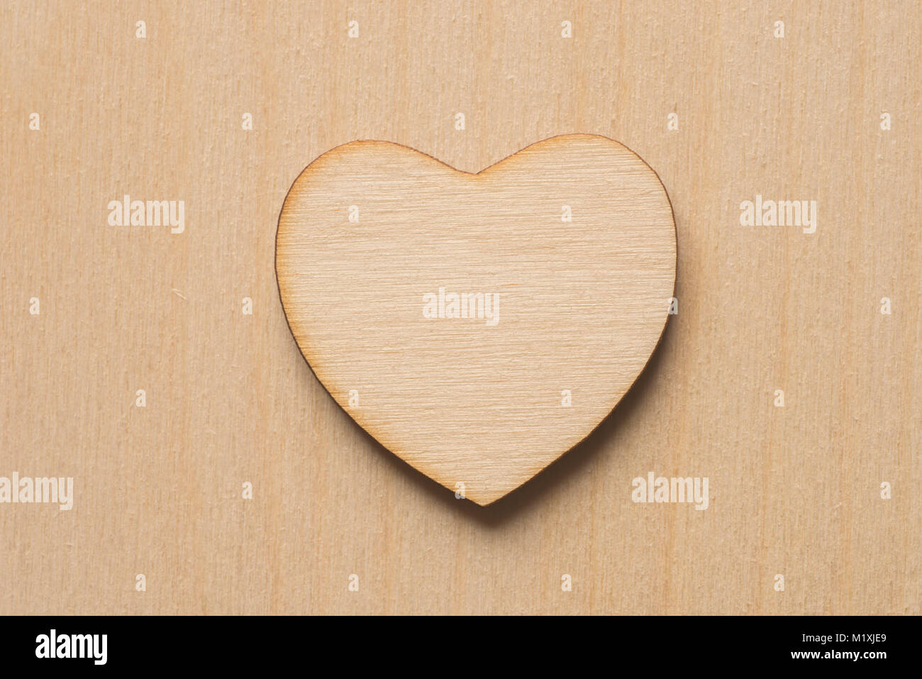 wooden heart macro on plywood background Stock Photo
