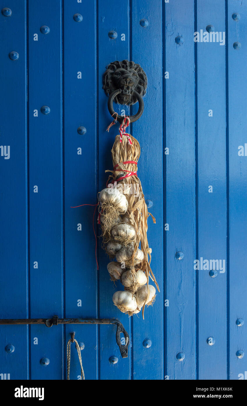 garlic braid on a blue door background Stock Photo