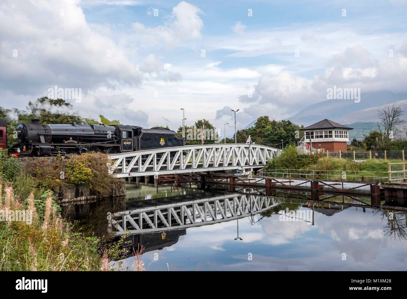 View from  Caledonian Canal looking towards the bridge and Railway line at Banavie railway station with ben nevis mountain range in the background and Stock Photo