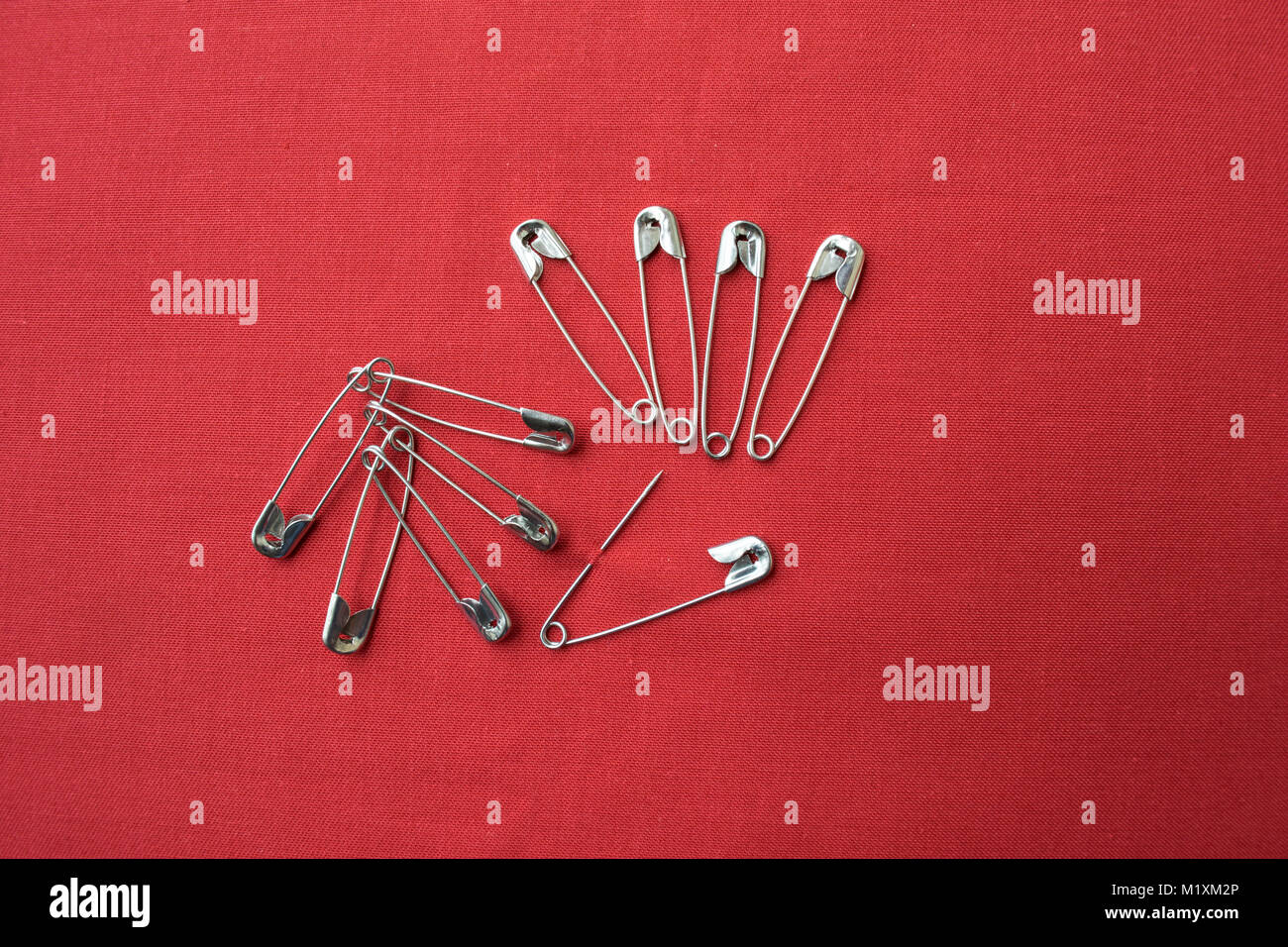 Many safety pins against red background Stock Photo Alamy