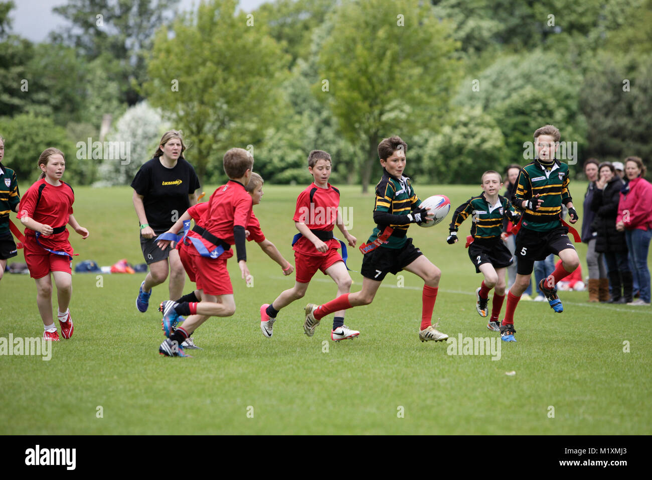 Girls and boys playing Tag Rugby in The midlands on a rainy Afternoon in Spring. Stock Photo