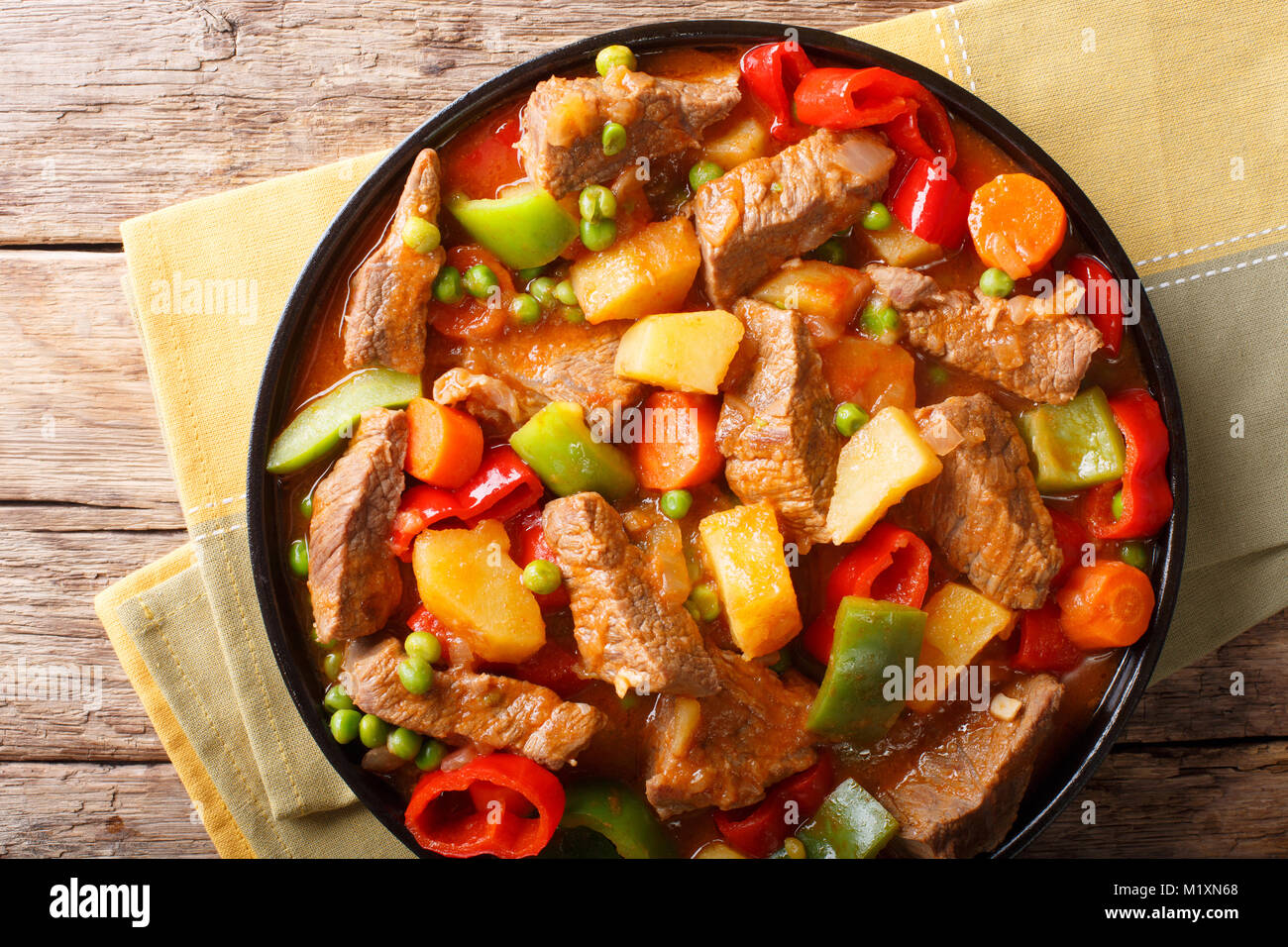 Slow cooked beef with potatoes, peppers, peas, tomatoes and carrots in