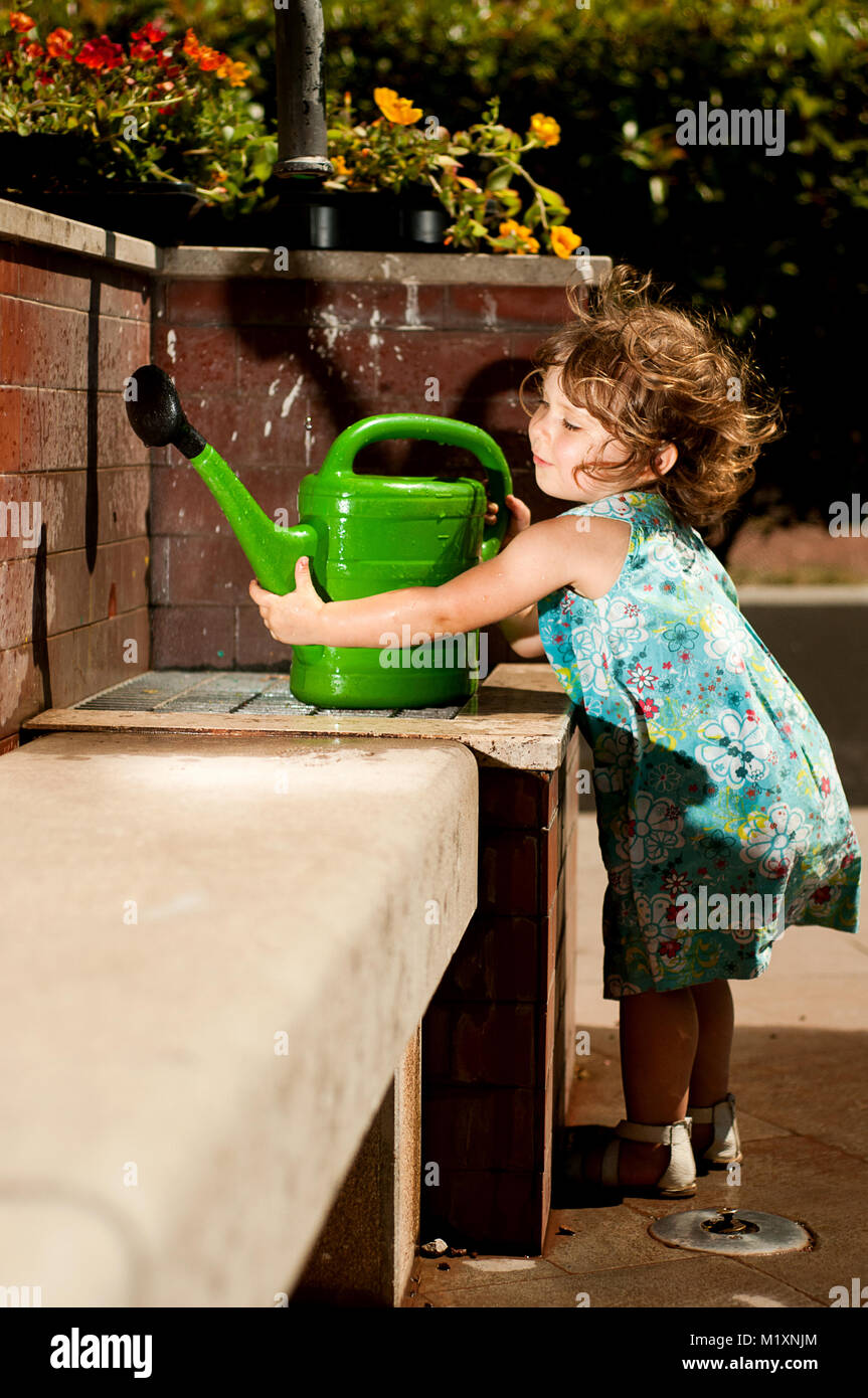 Baby with watering pot Stock Photo