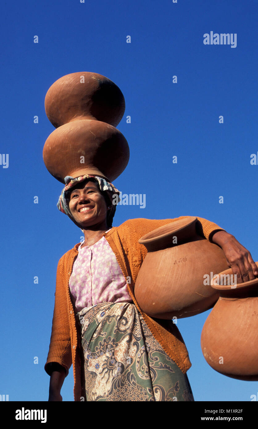 Myanmar (Burma). Mandalay. Ayeyarwady (Irradwaddy) river. Woman unloading pottery. Stock Photo