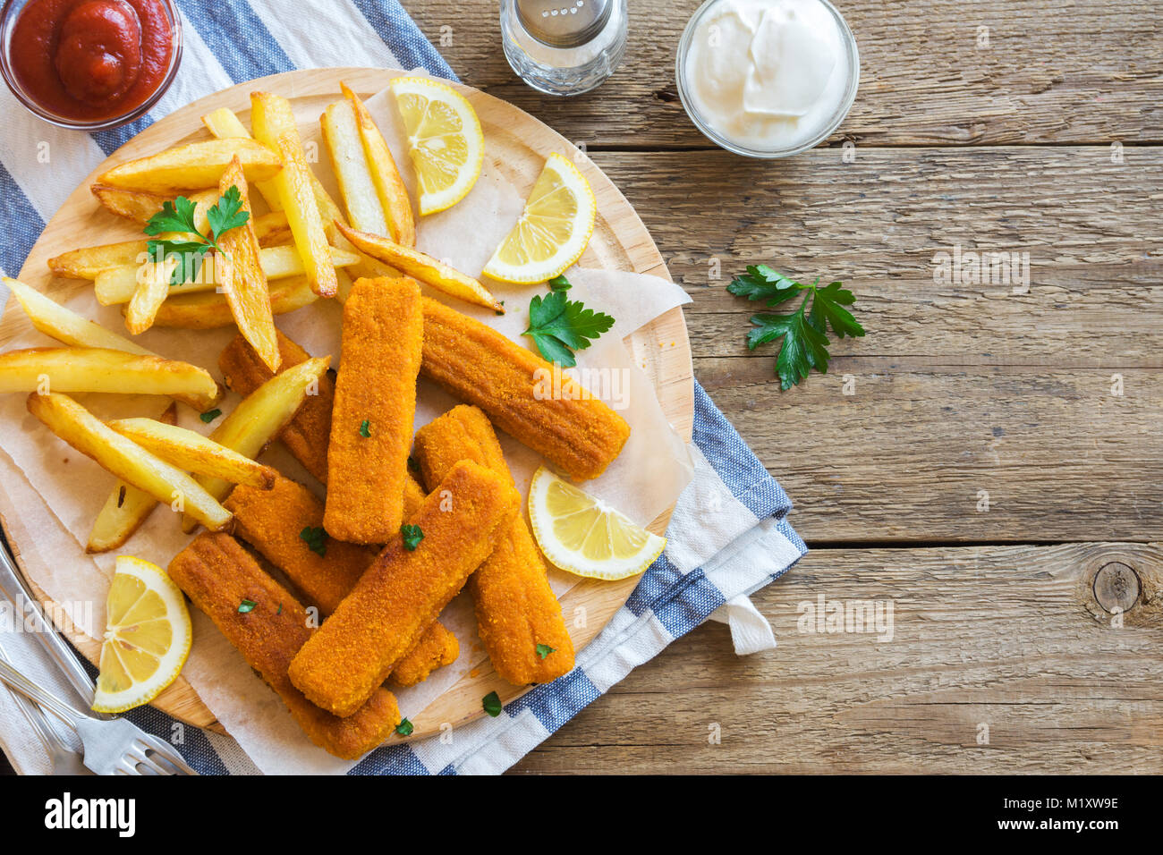 Fried Fish Sticks with French Fries. Fish Fingers over wooden