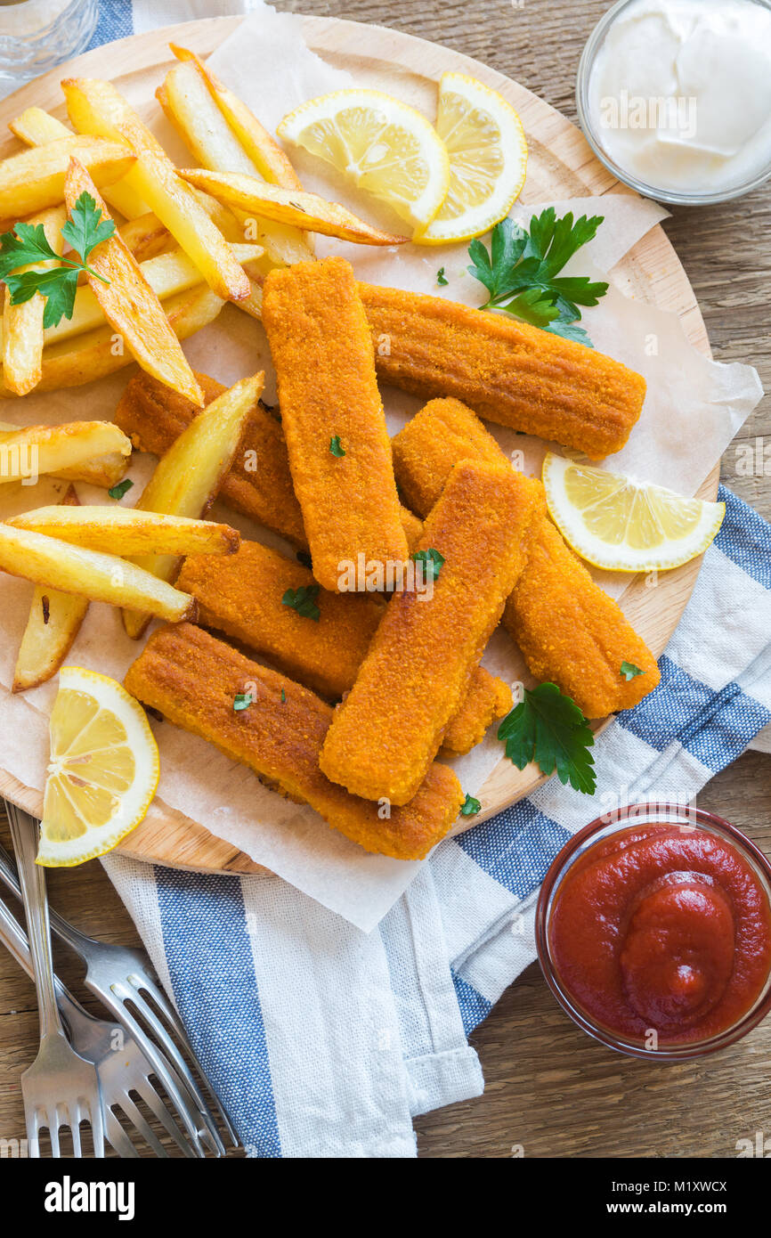 Fried Fish Sticks with French Fries. Fish Fingers over wooden