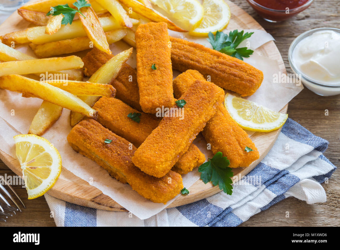 Fried Fish Sticks with French Fries. Fish Fingers over wooden