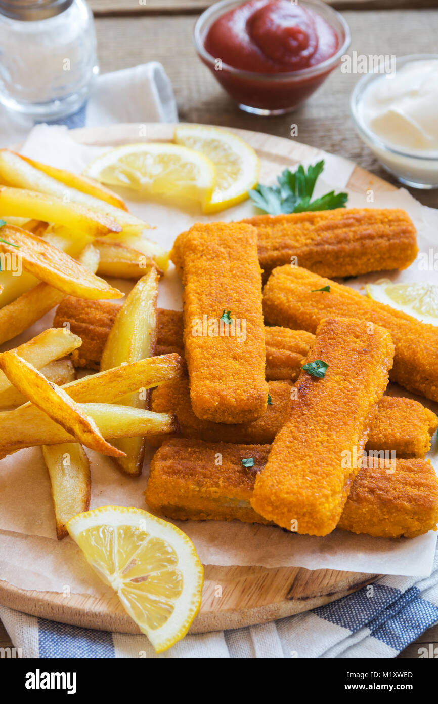 Fried Fish Sticks with French Fries. Fish Fingers over wooden