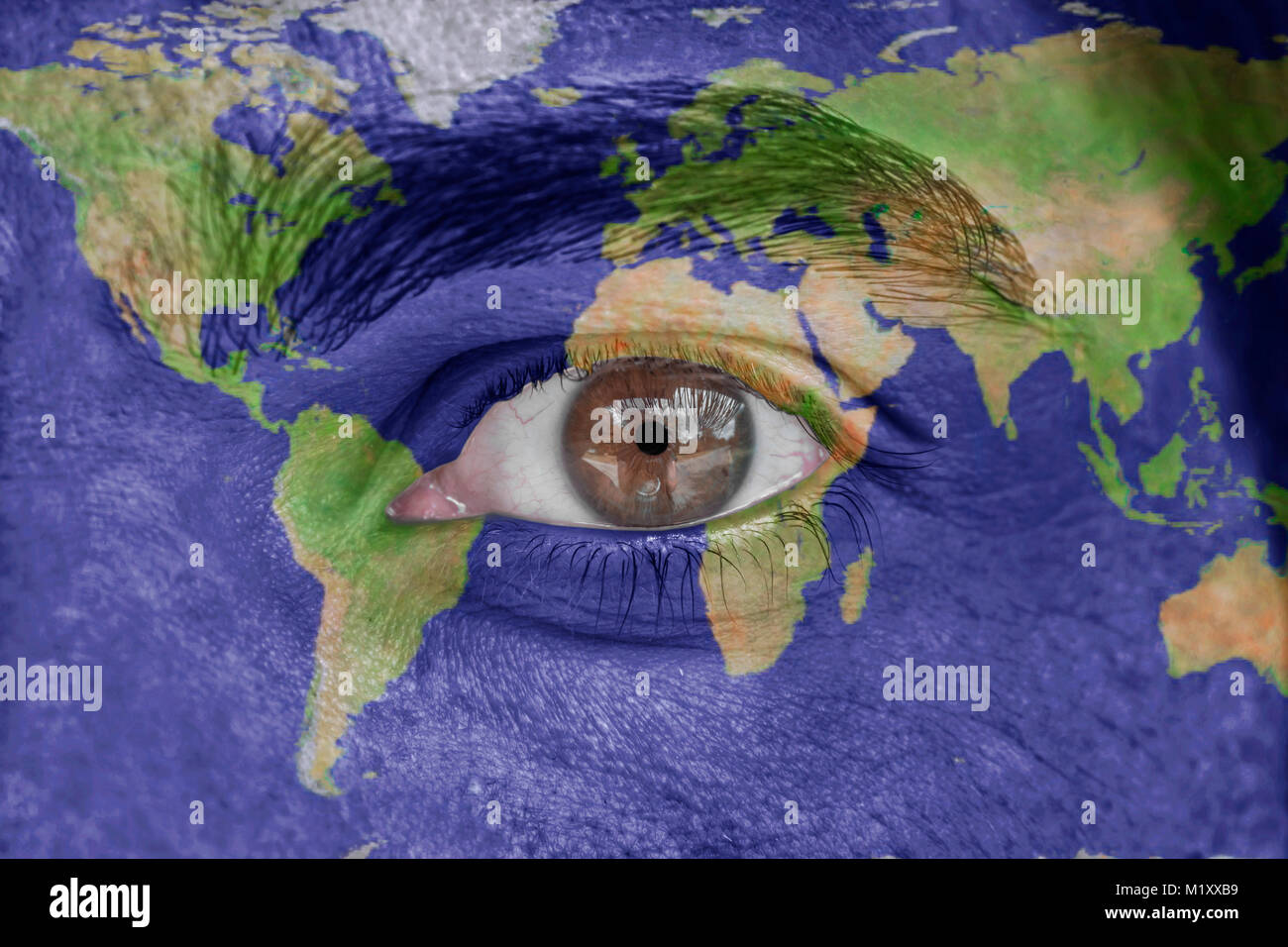 Human face and eye painted with world space geography map Stock Photo