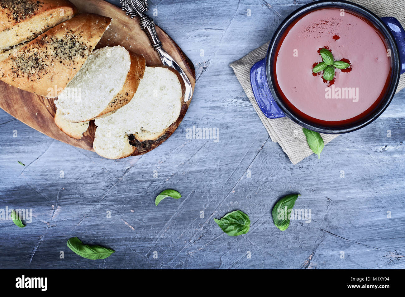 Hot tomato soup with basil leaves. Image shot from above in flat lay style. Stock Photo