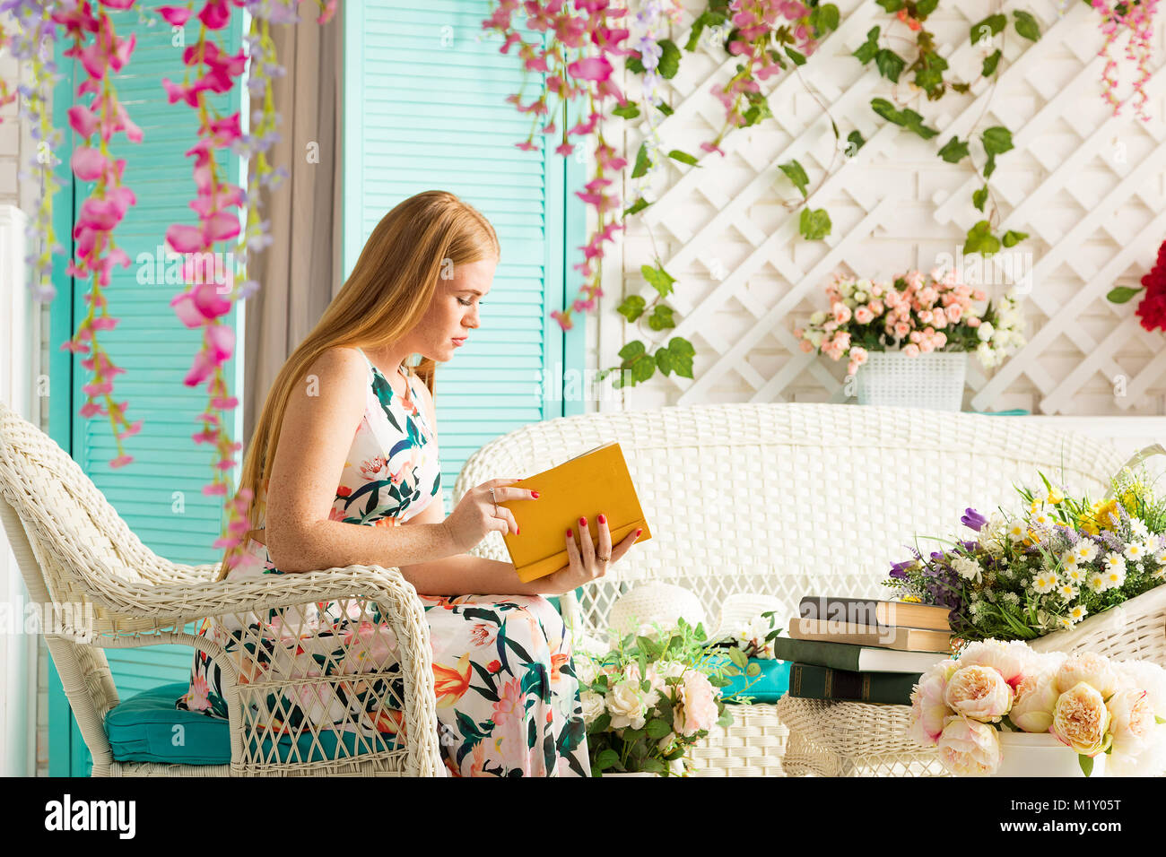 young woman with book in summer terrace Stock Photo