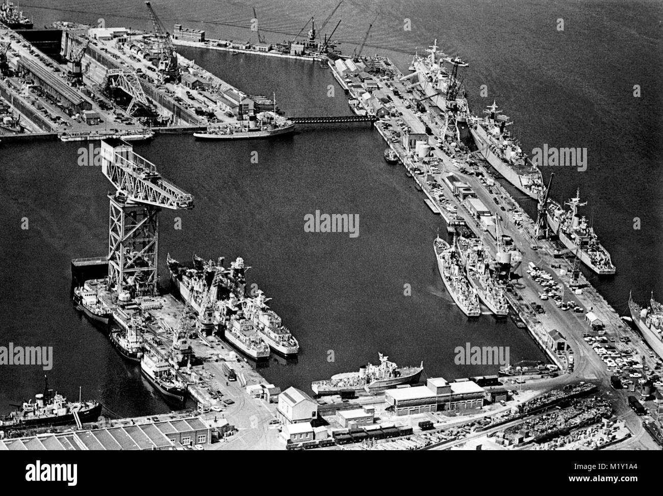 AJAXNETPHOTO. 19TH JANUARY, 1972. PORTSMOUTH, ENGLAND - NAVAL BASE - A GIANT 250 TON HAMMERHEAD CRANE DOMINATES NR 3 BASIN AND IS A LANDMARK FOR MILES AROUND THE CITY. THE BASIN WAS CREATED OUT OF THREE EARLIER BASINS. NORTH WEST WALL AND FOUNTAIN LAKE JETTY CAN BE SEEN TOP AND RIGHT. PHOTO:JONATHAN EASTLAND/AJAX REF:357241 PNB 01 Stock Photo